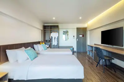 a hotel room with two beds and a flat screen tv at SureStay by Best Western Iconic Ari-Jatujak in Bangkok