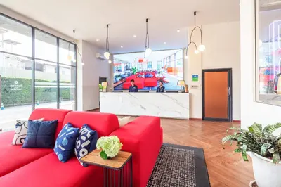 a red couch in the lobby of a store at SureStay by Best Western Iconic Ari-Jatujak in Bangkok