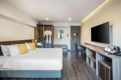 a hotel room with a bed and a flat screen tv at SureStay by Best Western Iconic Ari-Jatujak in Bangkok