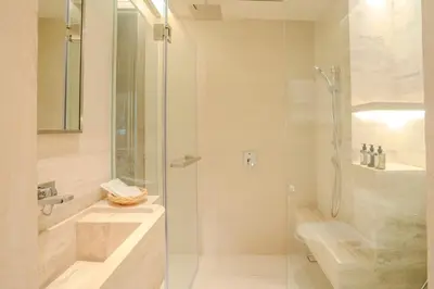 a bathroom with a glass shower and a sink at Inn a day in Bangkok