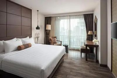a bedroom with a large white bed and a desk at Casa Nithra Bangkok in Bangkok