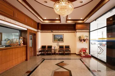 a lobby with a dining area and a chandelier at L.A. Tower Hotel in Bangkok