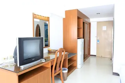 a living room with a television on a desk at L.A. Tower Hotel in Bangkok