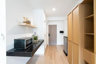 a small kitchen with a microwave on a black counter at L.A. Tower Hotel in Bangkok