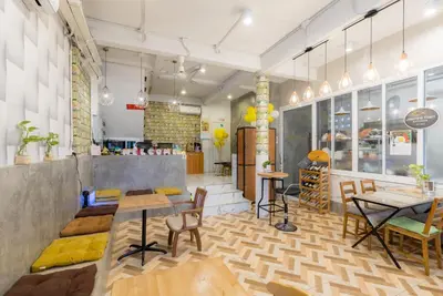 a restaurant with tables and chairs in a room at Lemon Siam Hostel Free Breakfast in Bangkok