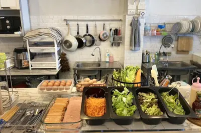 a kitchen with a counter with vegetables and eggs at Lemon Siam Hostel Free Breakfast in Bangkok