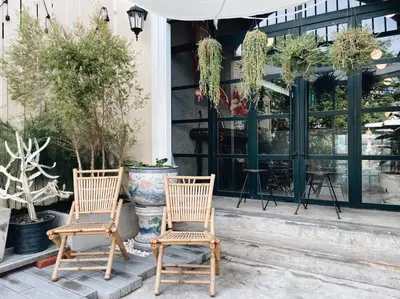 two chairs sitting in front of a building with plants at Tim Mansion in Bangkok
