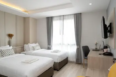 a hotel room with two beds and a window at The Riski Hotel at Bangphlat Station SHA in Bangkok