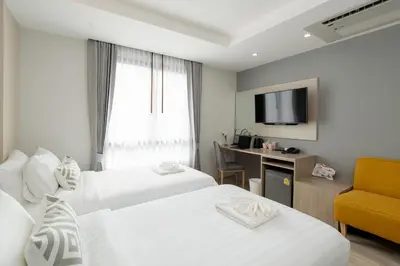 a hotel room with two beds and a television at The Riski Hotel at Bangphlat Station SHA in Bangkok