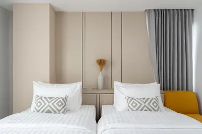two beds sitting next to each other in a room at The Riski Hotel at Bangphlat Station SHA in Bangkok