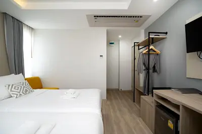 a bedroom with a bed and a dresser and a closet at The Riski Hotel at Bangphlat Station SHA in Bangkok