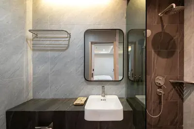 a bathroom with a sink and a mirror at The Riski Hotel at Bangphlat Station SHA in Bangkok