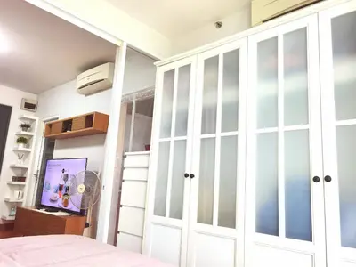 a bedroom with white cabinets and a bed at Rama9 Cozy Apartment in Bangkok