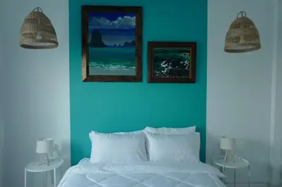 a blue bedroom with a bed and two pictures on the wall at Baan Suandao Wat Arun in Bangkok