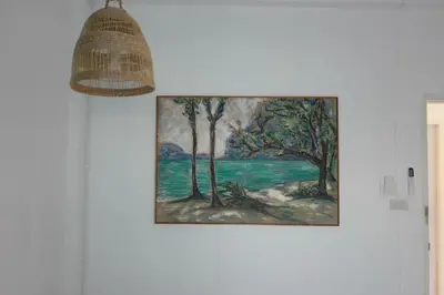 a painting hanging on a wall with a lamp at Baan Suandao Wat Arun in Bangkok