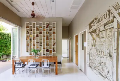 a dining room with a wooden table and chairs at Siamaze Hostel in Bangkok