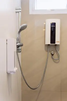a shower with a hose attached to a wall at Siamaze Hostel in Bangkok