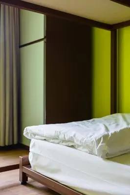 two unmade beds in a room with green walls at Siamaze Hostel in Bangkok