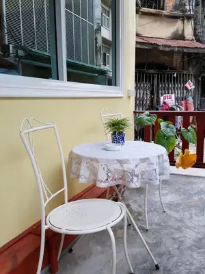 a table and two chairs with a plant on it at Bangkok Check Inn @Chareon Krung in Bangkok