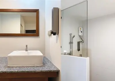 a bathroom with a sink and a mirror at Niagara Hotel in Bangkok
