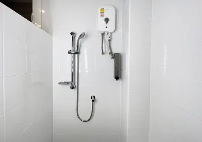 a shower stall in a bathroom with a hand dryer at Niagara Hotel in Bangkok