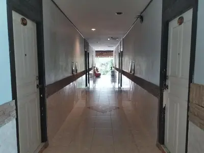 an empty hallway with doors and a tile floor at Platinum Place in Bangkok