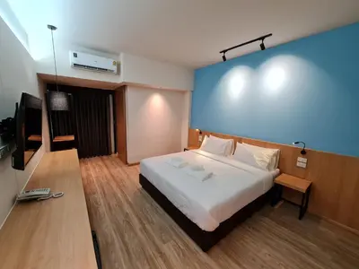 a hotel room with a bed and a television at The Neuf@Ratchada in Bangkok