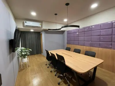 a conference room with a wooden table and chairs at The Neuf@Ratchada in Bangkok
