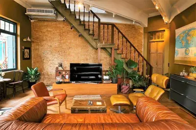a living room with a couch and a brick wall at Ba Hao Residence in Bangkok