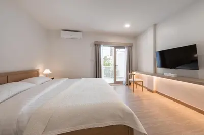 a bedroom with a large bed and a flat screen tv at COROOM BKK in Bangkok