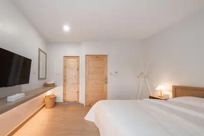 a bedroom with a bed and a tv and two doors at COROOM BKK in Bangkok