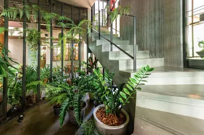 a bunch of plants in a room with a staircase at Tamni in Bangkok