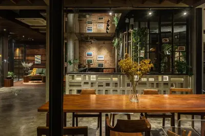 a table with a vase of flowers on it at Tamni in Bangkok