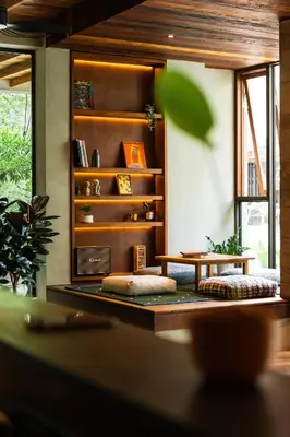 a living room with a table and a book shelf at Tamni in Bangkok