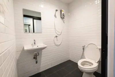 a white bathroom with a toilet and a sink at WiRE BANGKOK PRAKHANONG in Amphoe Phra Khanong