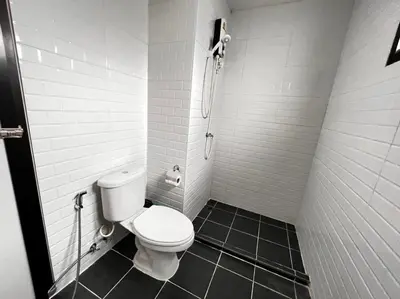 a small bathroom with a toilet and a shower at WiRE BANGKOK PRAKHANONG in Amphoe Phra Khanong