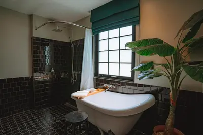 a bathroom with a tub and a plant in it at Hotel Thomas Bangkok in Makkasan