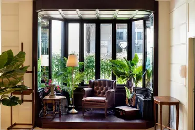 a living room with a chair and some plants at Hotel Thomas Bangkok in Makkasan