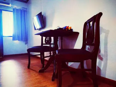 a room with a table and two chairs and a television at Beerapan Hotel in Bangkok