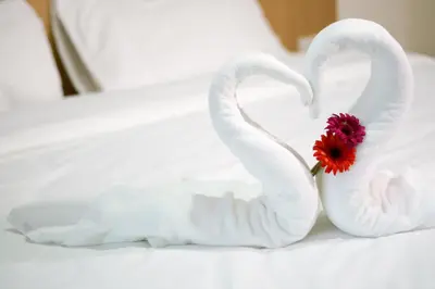 two swans made out of towels with a flower at Beerapan Hotel in Bangkok