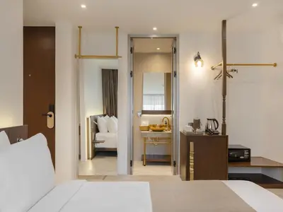 a bedroom with a bed and a desk and a chair at Nidhra Boutique Hotel Bangkok Sukhumvit in Bangkok