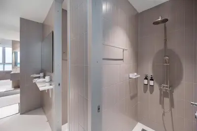 a bathroom with a shower and a sink at Nidhra Boutique Hotel Bangkok Sukhumvit in Bangkok