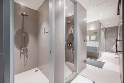 a bathroom with a shower and a sink at Nidhra Boutique Hotel Bangkok Sukhumvit in Bangkok