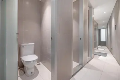 a bathroom with a toilet and a walk in shower at Nidhra Boutique Hotel Bangkok Sukhumvit in Bangkok