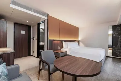 a hotel room with a bed and a table at Gardina Asoke Hotel & Residence in Bangkok