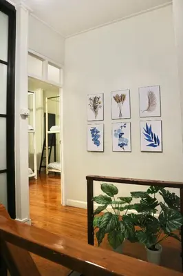 a living room with blue and white pictures on the wall at Dara Three Hostel ดาราตรี in Bangkok