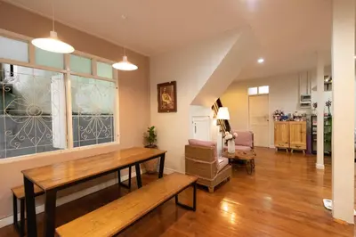 a living room with a table and a couch at Dara Three Hostel ดาราตรี in Bangkok