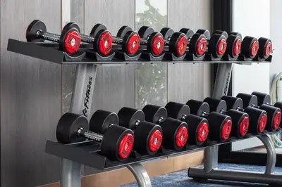 a rack of red dumbbells in a gym at Wyndham Bangkok Queen Convention Centre in Bangkok
