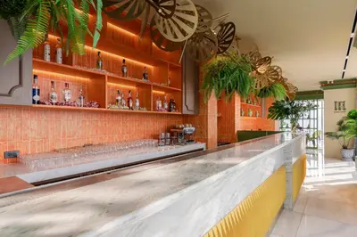 a bar with a long counter in a room at Wyndham Bangkok Queen Convention Centre in Bangkok
