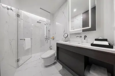 a bathroom with a toilet and a shower and a sink at Wyndham Bangkok Queen Convention Centre in Bangkok
